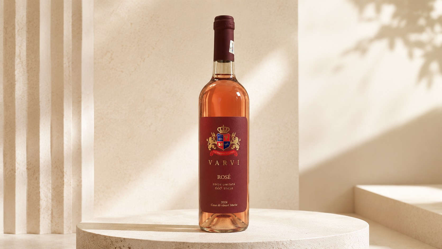Sticlă de VARVI Rosé cu etichetă vișinie, pe un piedestal de piatră